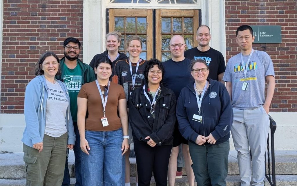 Photo of a group of people standing in front of a brick building